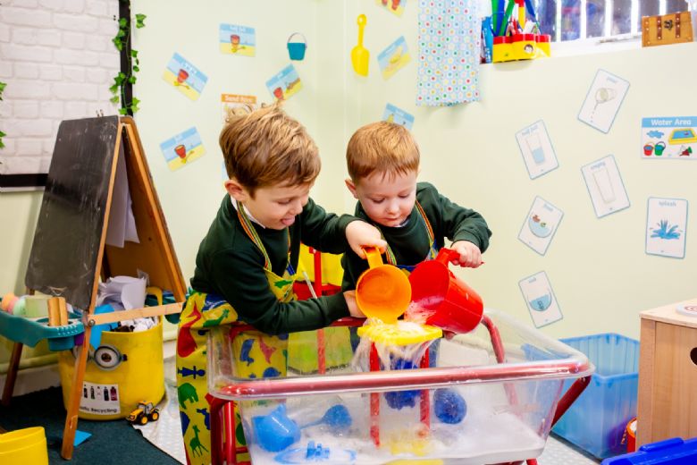 Young boys playing in the water tray 
